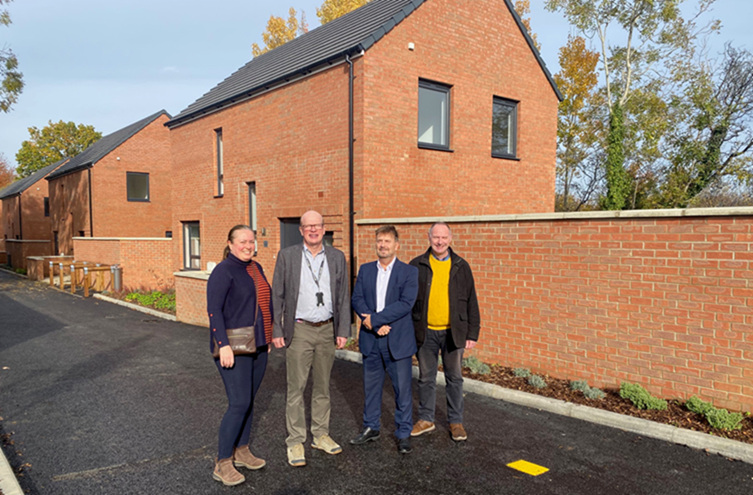 Title: A group of people standing in front of a brick building

AI-generated content may be incorrect.