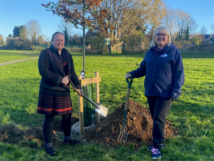 Title: Two women holding shovels and a pile of dirt
AI-generated content may be incorrect.